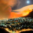 groothoek beeld van Kaapstad in de avond. Op de tafelberg zijn oranje vlammen te zijn en een dikke rookwolk waait de stad in