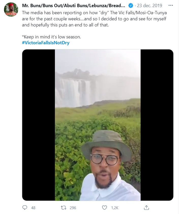 Een twitter screenshot onder de hashtag Victoria Falls is not dry met een foto van een man die vlak voor de denderende waterval staat.