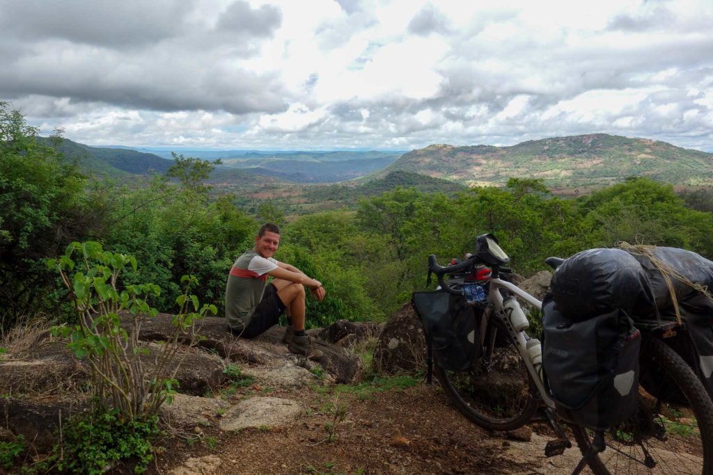 Niels, geniet van zijn uitzicht over de groene heuvels in Afrika