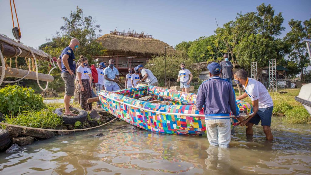 A smaller boat made of plastic is being dragged into the water