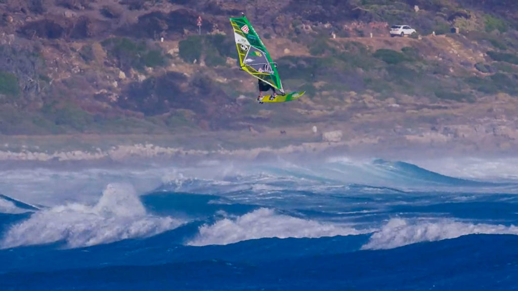 Een wavesailer maakt enkele meters airtime in Kaapstad door de snelheid van wavesailing